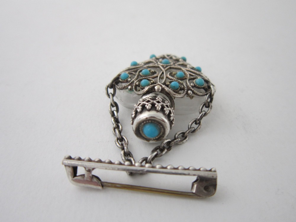 A 1920s Continental silver scent bottle featuring clear glass enclosed in silver filigree overlay set with turquoise cabochons, suspended from a beaded bar pin. View III