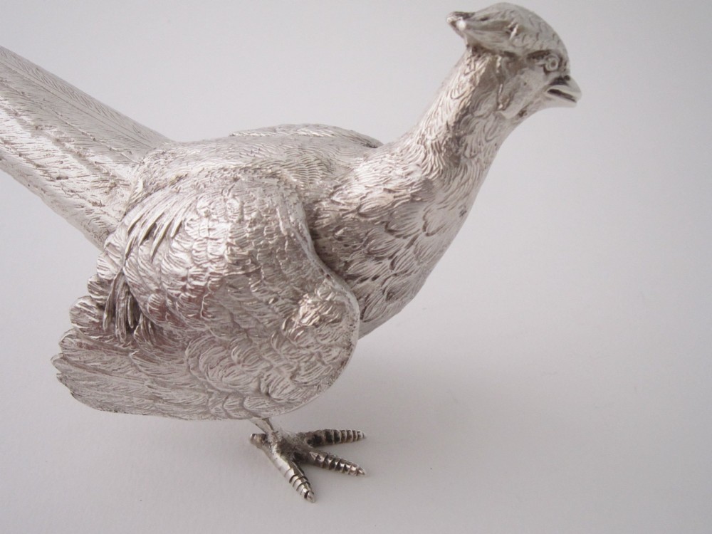 A pair of detailed cast sterling silver pheasants portrayed in naturalistic poses against a light background. View V
