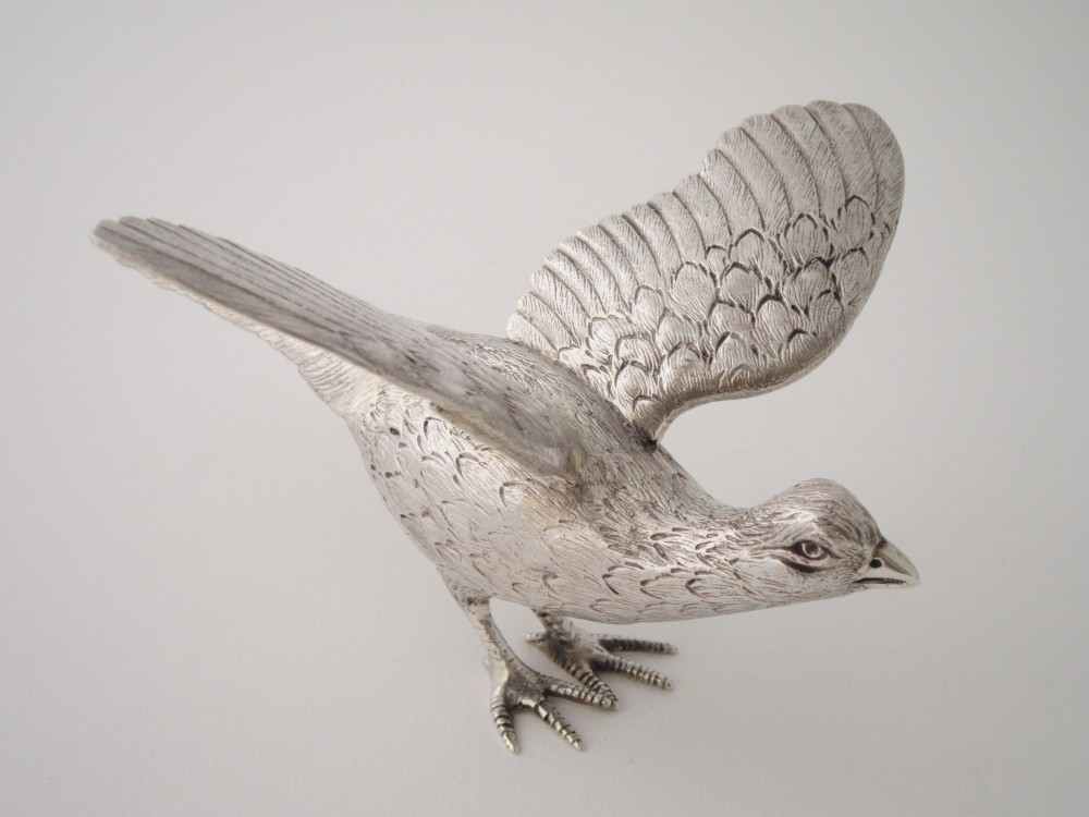 A pair of detailed cast sterling silver pheasants portrayed in naturalistic poses against a light background. View VIII