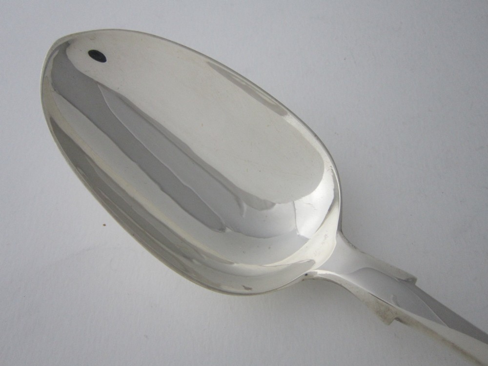 An antique Victorian sterling silver basting spoon featuring a fiddle pattern handle and polished oval bowl. View II