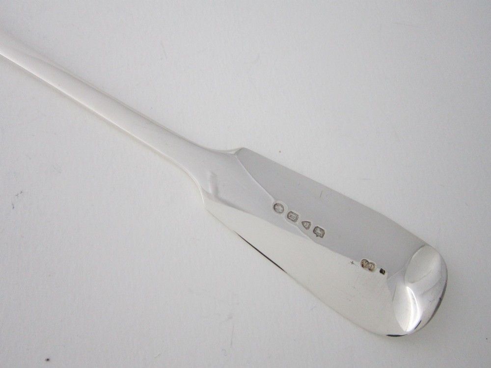 An antique Victorian sterling silver basting spoon featuring a fiddle pattern handle and polished oval bowl. View VI