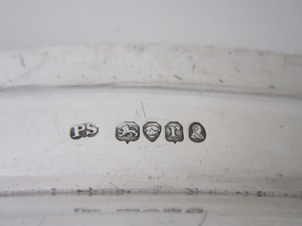 An oval William IV sterling silver meat platter featuring a decorative gadrooned border and an engraved coat of arms on the upper rim. View VI