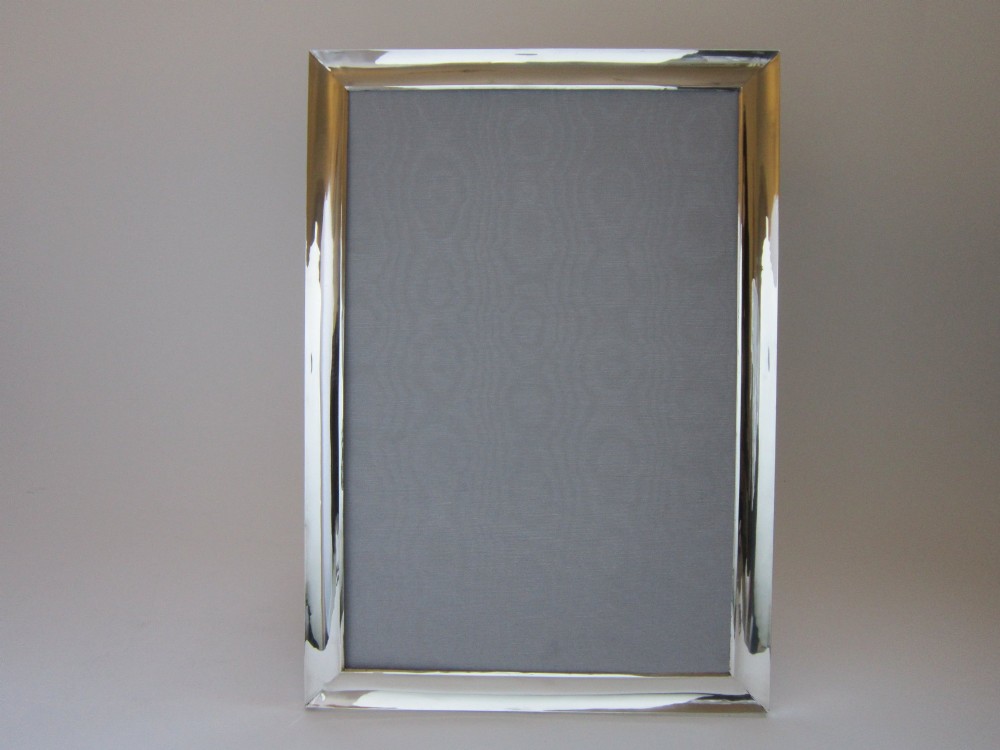 A rectangular George V sterling silver photograph frame with a plain polished moulding presented in a horizontal orientation. View II