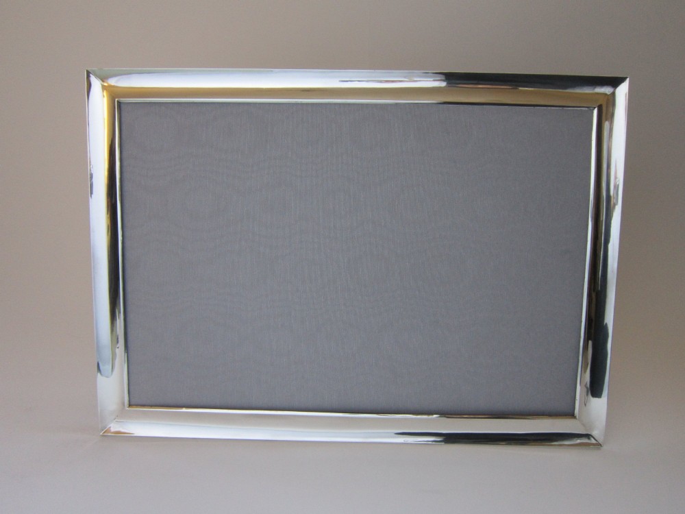 A rectangular George V sterling silver photograph frame with a plain polished moulding presented in a horizontal orientation. View III