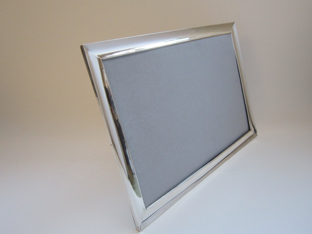 A rectangular George V sterling silver photograph frame with a plain polished moulding presented in a horizontal orientation. View VII