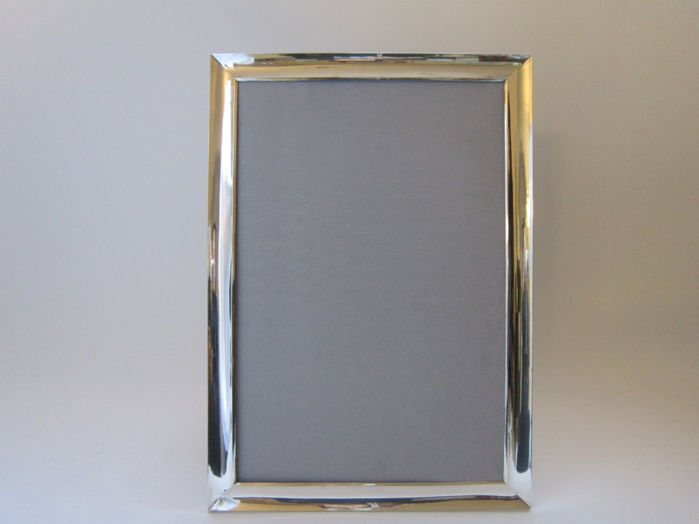 A rectangular George V sterling silver photograph frame with a plain polished moulding presented in a horizontal orientation. View VIII