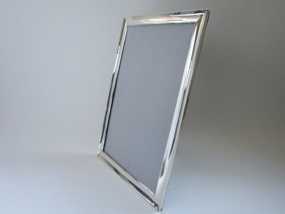 A rectangular George V sterling silver photograph frame with a plain polished moulding presented in a horizontal orientation. View IX