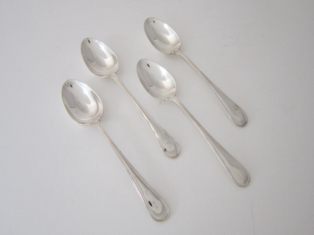 An antique George V sterling silver egg cruet featuring a central carrying handle, six egg cups, and matching spoons arranged on an oval tray base. View XI