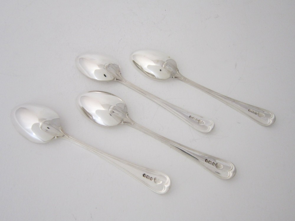 An antique George V sterling silver egg cruet featuring a central carrying handle, six egg cups, and matching spoons arranged on an oval tray base. View XII
