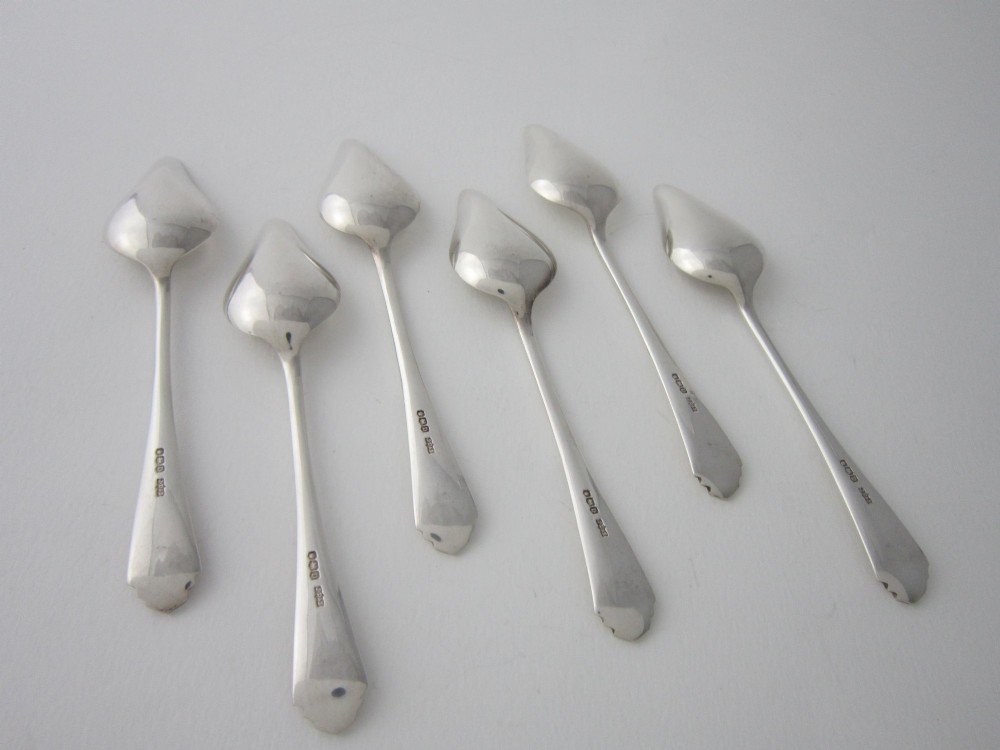 A set of six Art Deco sterling silver grapefruit spoons with pointed bowls and stepped handles displayed in an open presentation case. View V