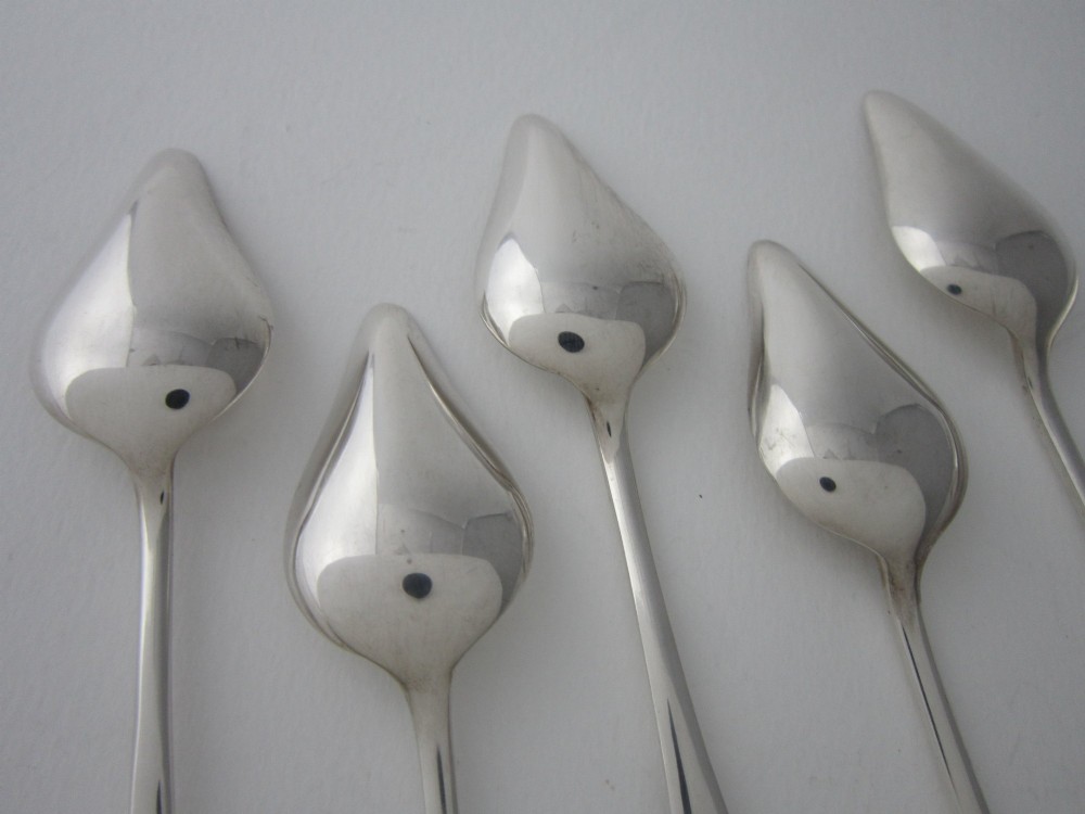 A set of six Art Deco sterling silver grapefruit spoons with pointed bowls and stepped handles displayed in an open presentation case. View VI