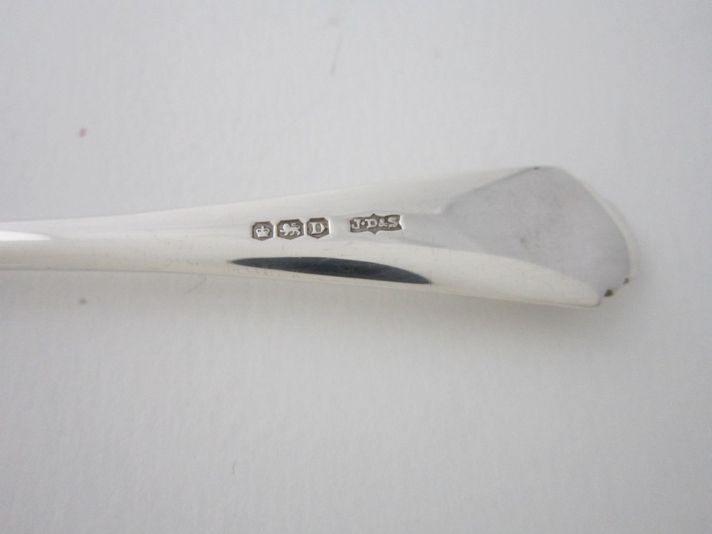 A set of six Art Deco sterling silver grapefruit spoons with pointed bowls and stepped handles displayed in an open presentation case. View VIII