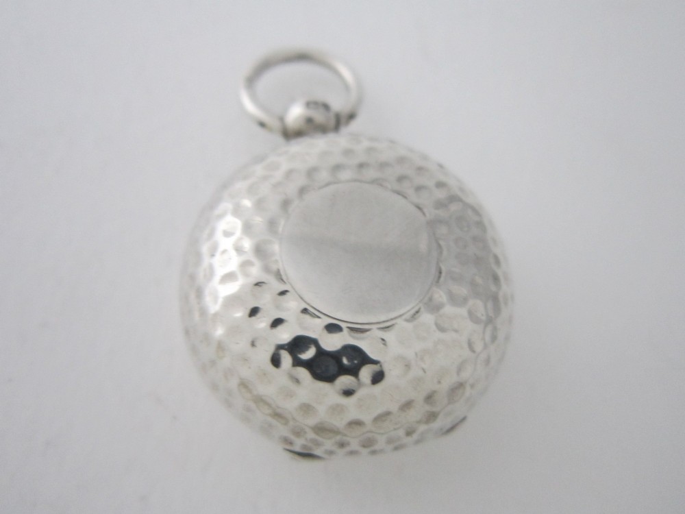 An Edwardian sterling silver sovereign case featuring a hammered circular exterior, a smooth central cartouche, and a top suspension ring. View II