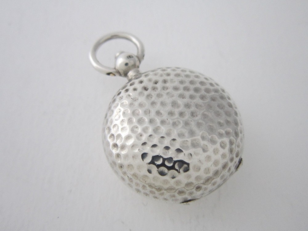 An Edwardian sterling silver sovereign case featuring a hammered circular exterior, a smooth central cartouche, and a top suspension ring. View III