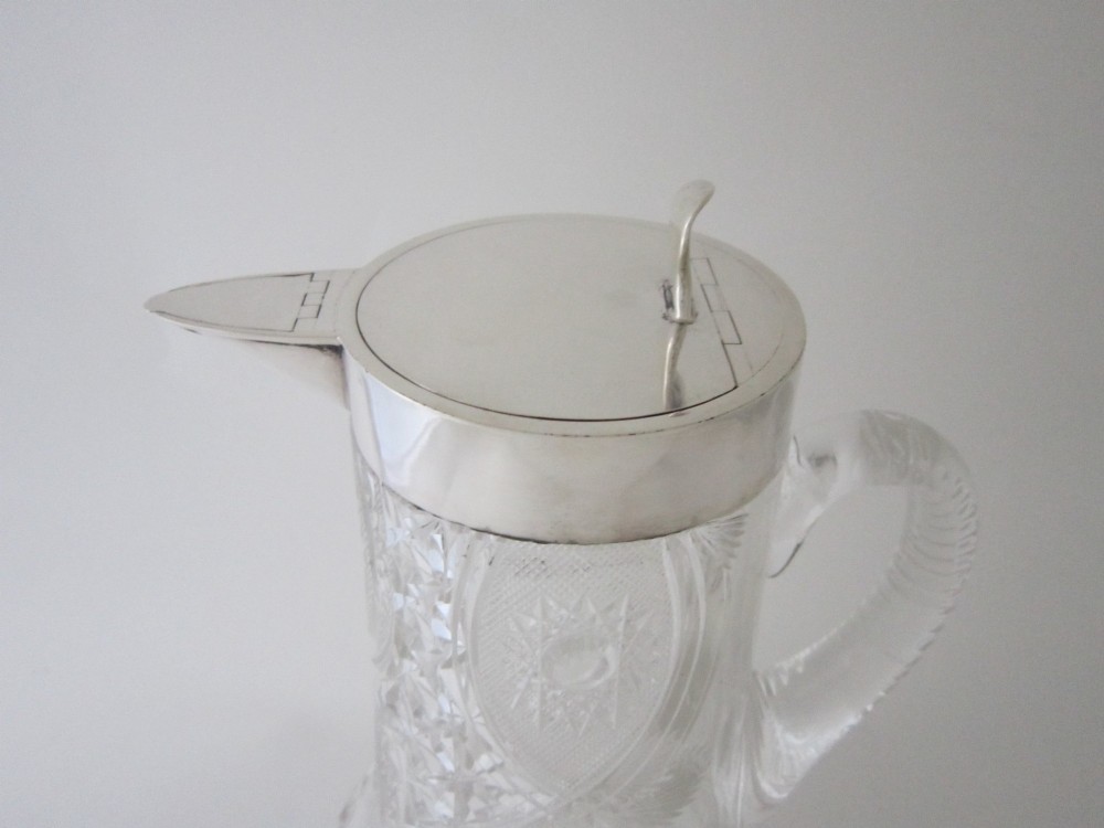 A large George V cut glass jug featuring a sterling silver collar and spout alongside a moulded glass handle. View II
