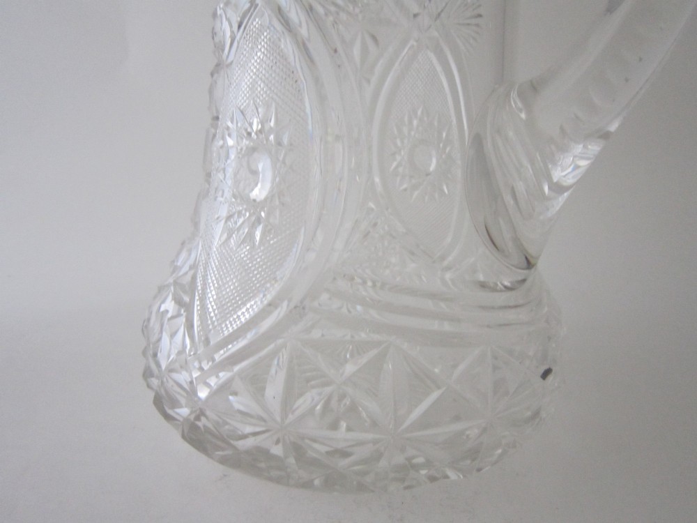 A large George V cut glass jug featuring a sterling silver collar and spout alongside a moulded glass handle. View V