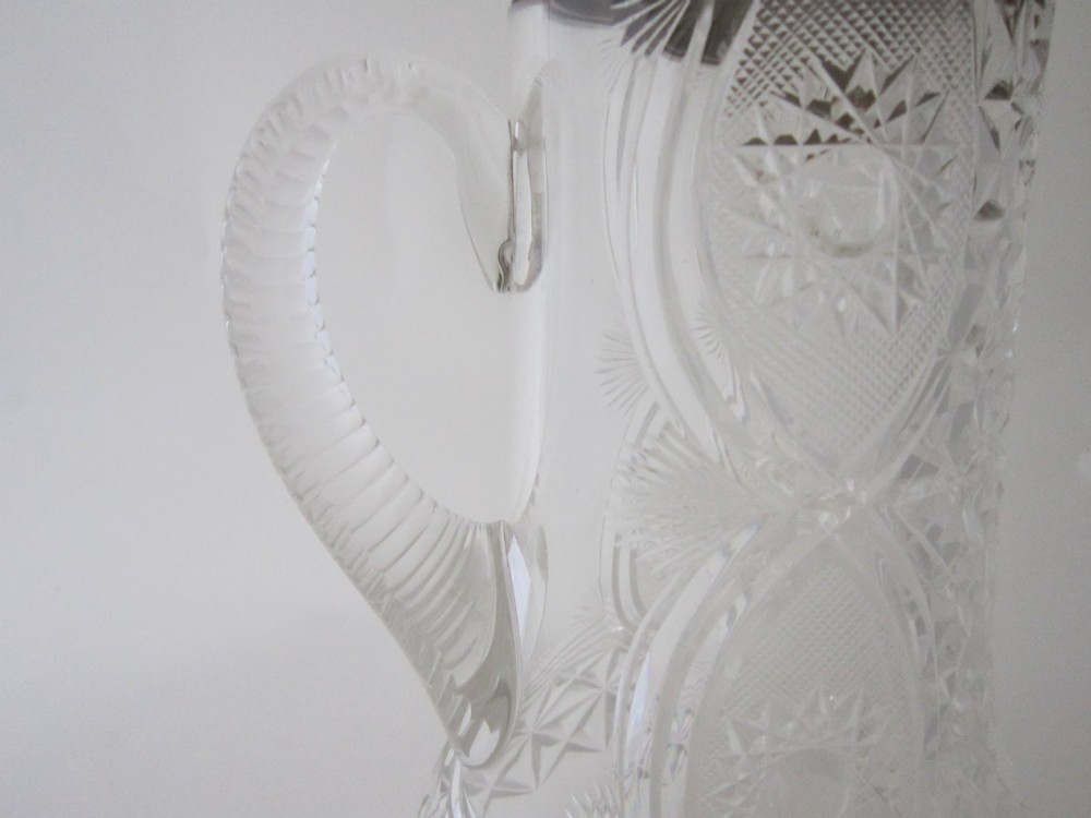 A large George V cut glass jug featuring a sterling silver collar and spout alongside a moulded glass handle. View VI