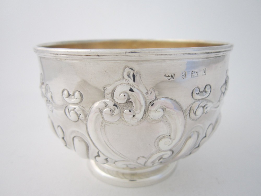 An Edwardian sterling silver bowl featuring embossed scrollwork decoration and a gilt interior. View II