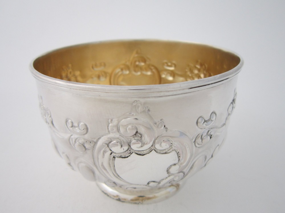 An Edwardian sterling silver bowl featuring embossed scrollwork decoration and a gilt interior. View IV