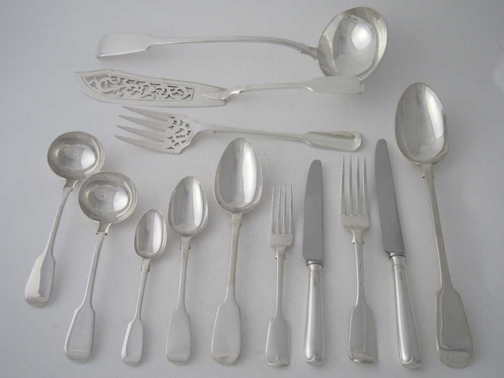 An open oak cutlery canteen with double doors revealing three fitted drawers filled with sterling silver flatware and featuring brass campaign handles. View IV