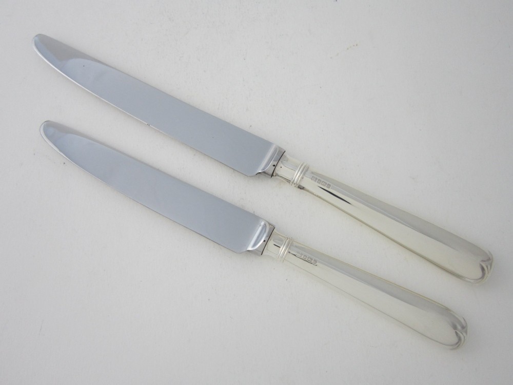 An open oak cutlery canteen with double doors revealing three fitted drawers filled with sterling silver flatware and featuring brass campaign handles. View XIV