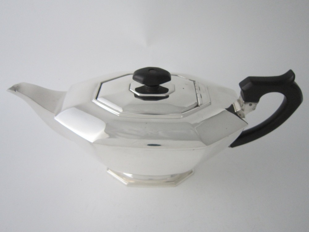 An octagonal sterling silver teapot featuring an ebonised wooden handle and matching black lid finial. View II