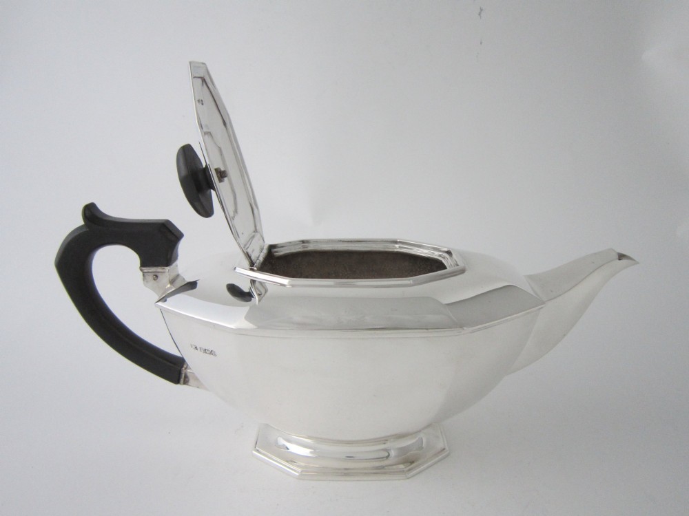 An octagonal sterling silver teapot featuring an ebonised wooden handle and matching black lid finial. View IV