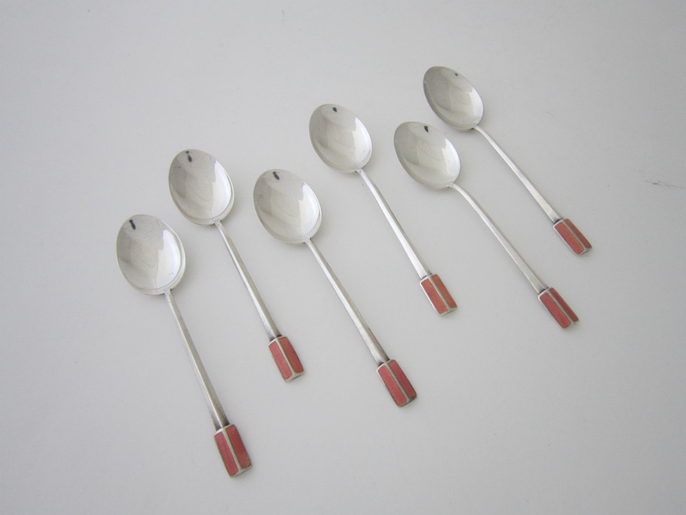 A set of six Art Deco sterling silver coffee spoons with pink enamelled terminals presented in an open blue silk and velvet lined case. View III