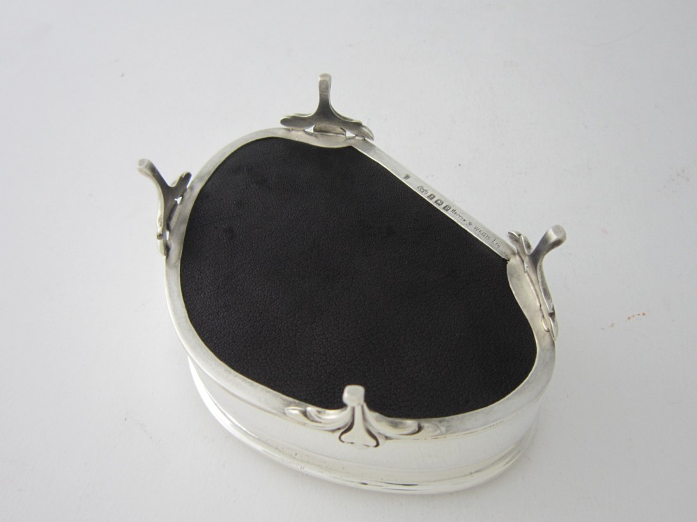A kidney-shaped antique sterling silver trinket box with a beaded edge hinged lid standing on small decorative feet. View VI