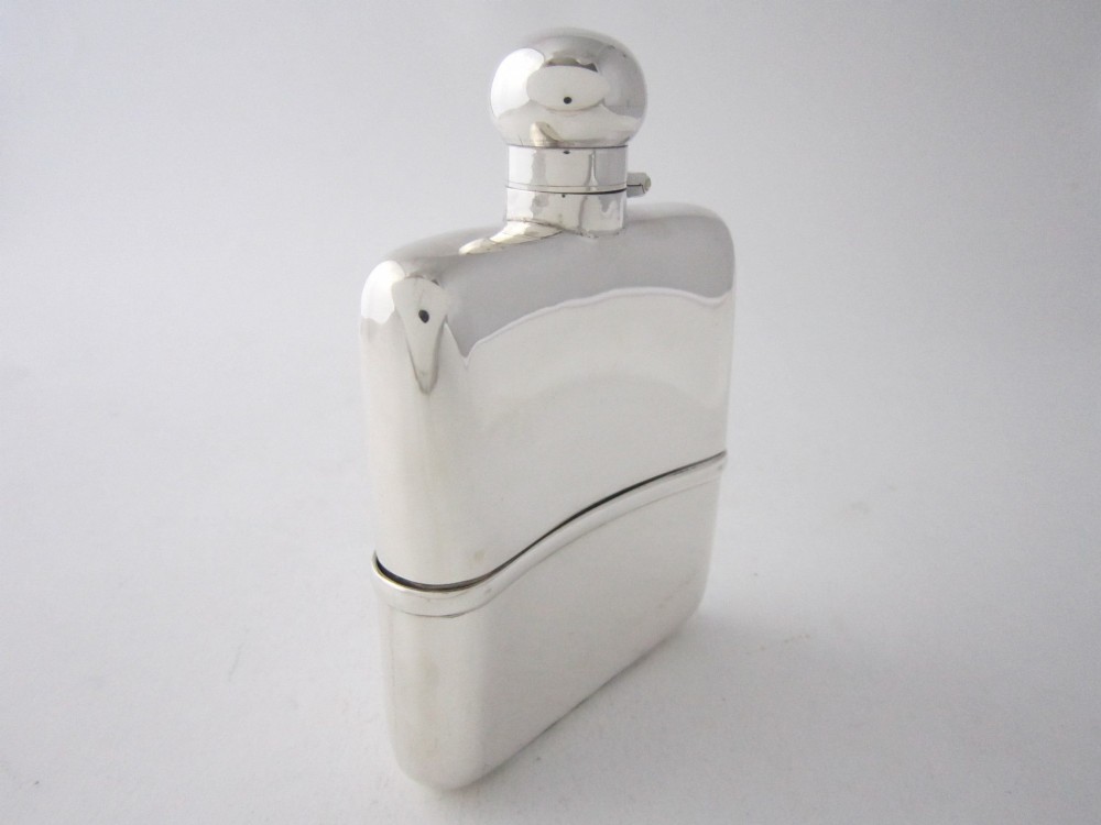 A curved sterling silver hip flask with a bayonet cap and stamped British hallmarks. View II