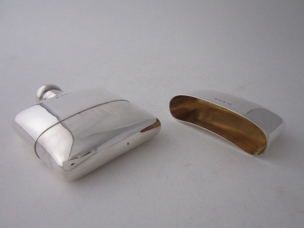 A curved sterling silver hip flask with a bayonet cap and stamped British hallmarks. View III