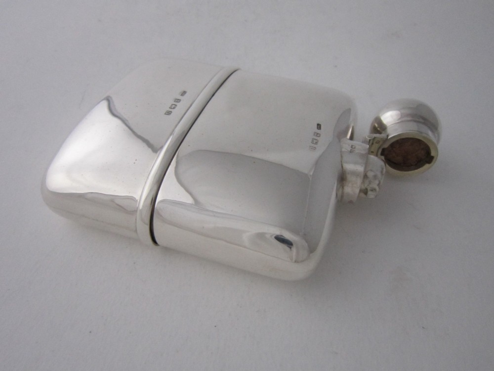 A curved sterling silver hip flask with a bayonet cap and stamped British hallmarks. View IV