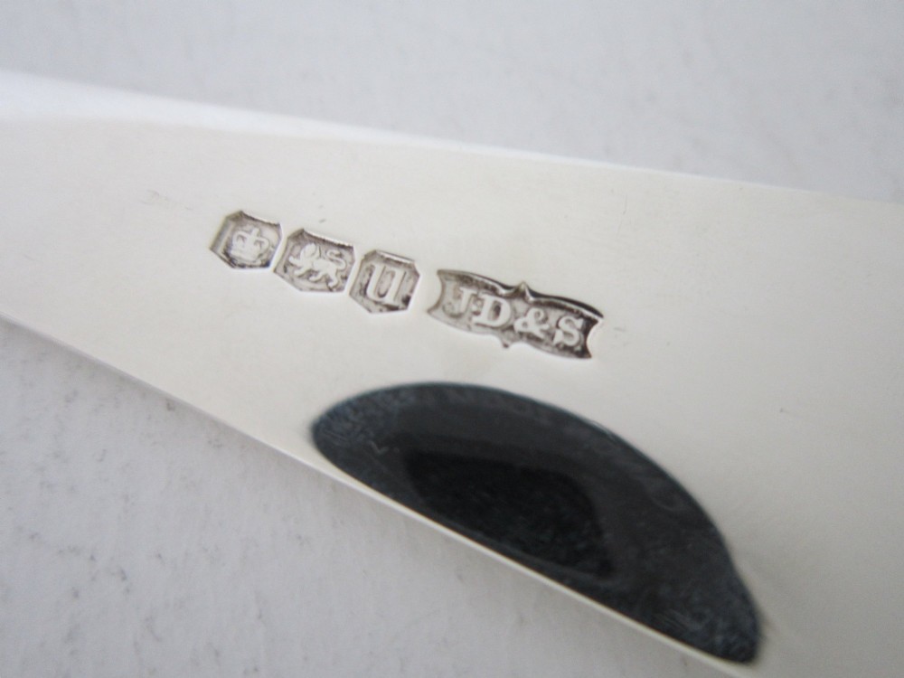 A sterling silver Stilton scoop featuring a curved rectangular shovel blade and a smooth Old English pattern handle. View VII