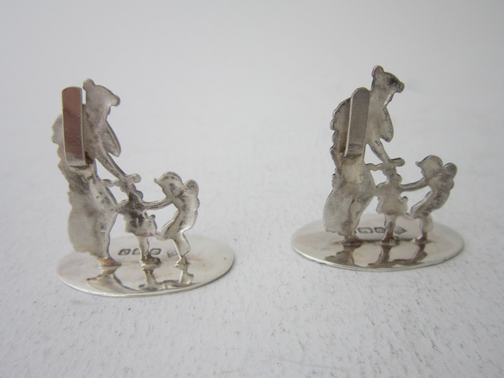 A pair of Edwardian sterling silver place card holders featuring classical female figures and cherubs on round hallmarked bases. View IV