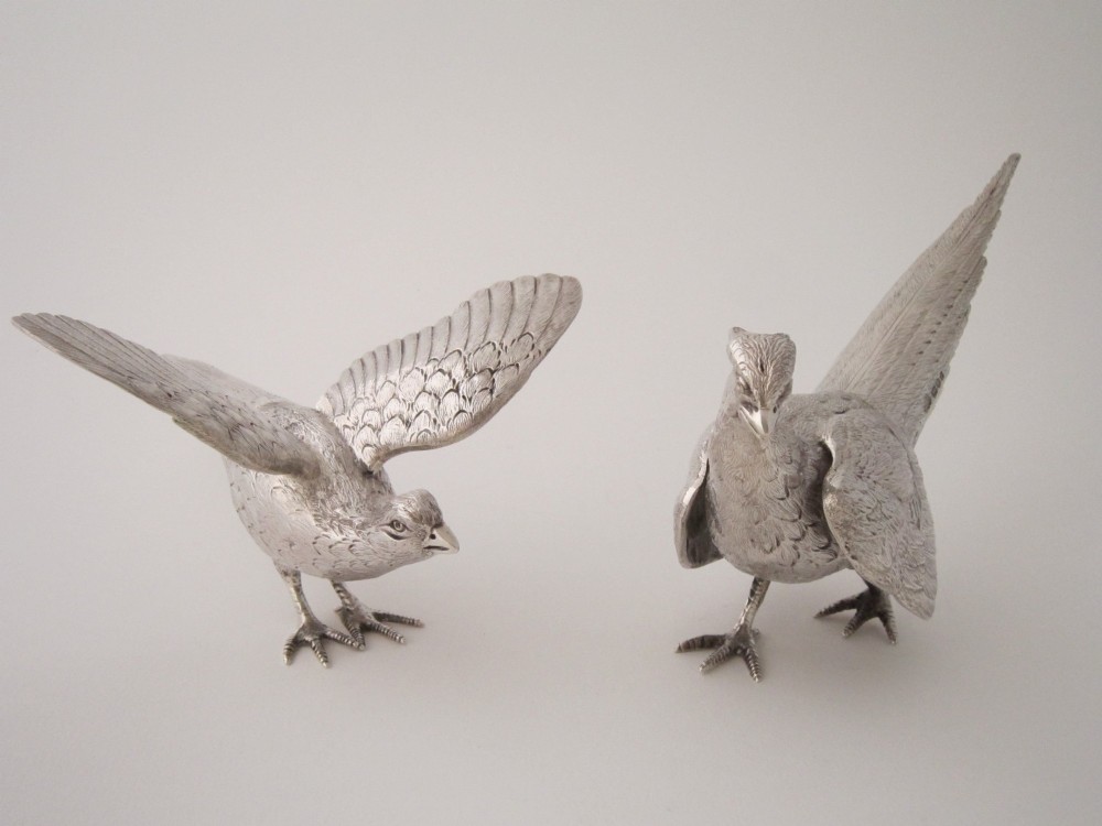 A pair of detailed sterling silver pheasant figurines positioned on a plain background. View III