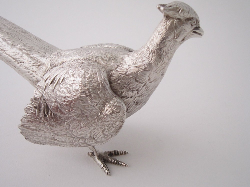 A pair of detailed sterling silver pheasant figurines positioned on a plain background. View V
