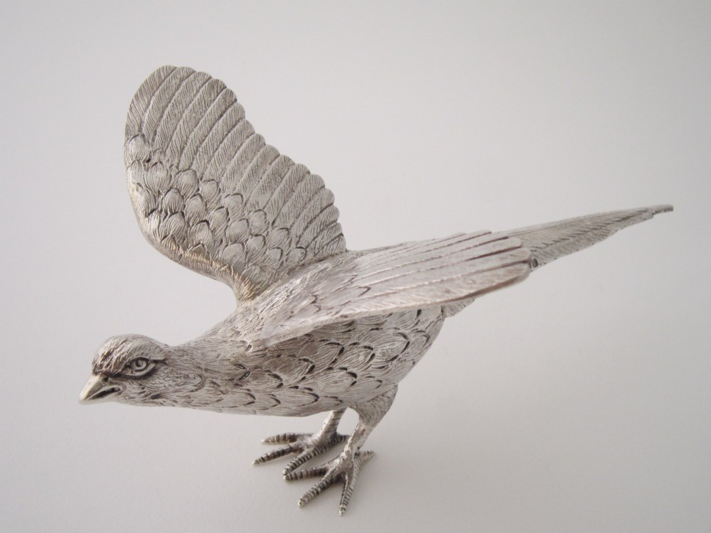 A pair of detailed sterling silver pheasant figurines positioned on a plain background. View IX