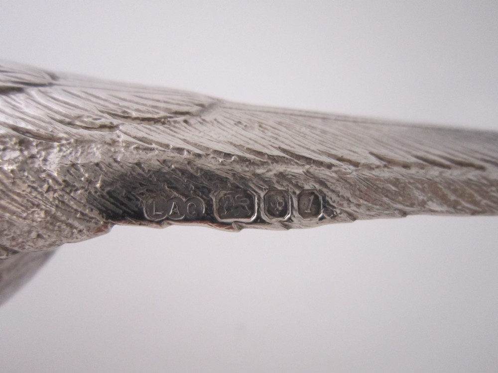 A pair of detailed sterling silver pheasant figurines positioned on a plain background. View XII