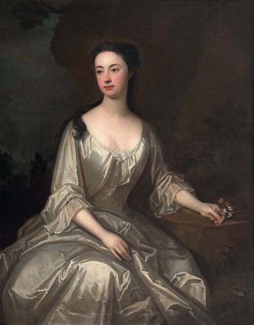 fig 1. An early eighteenth-century oil painting on canvas depicting a seated lady in a silk gown within a carved giltwood frame.