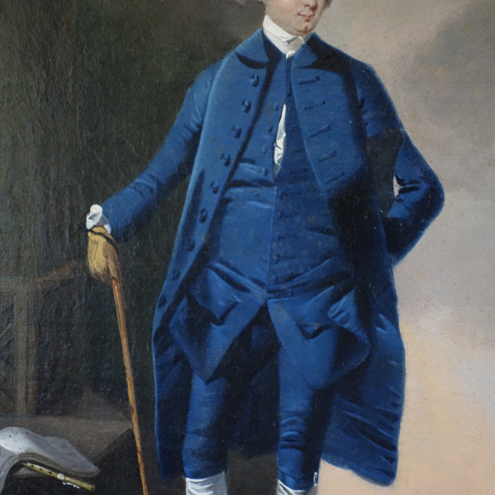 An 18th-century oil portrait of a gentleman wearing a blue frock coat and standing outdoors beside sheet music, displayed in a carved giltwood frame. View II