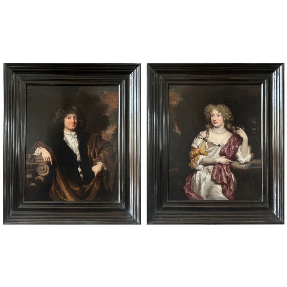 A pair of 17th-century Dutch oil portrait paintings depicting a gentleman and a lady in period clothing, framed in matching dark moulded frames.