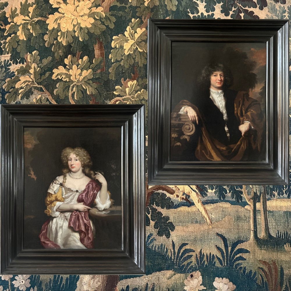 A pair of 17th-century Dutch oil portrait paintings depicting a gentleman and a lady in period clothing, framed in matching dark moulded frames. View IV