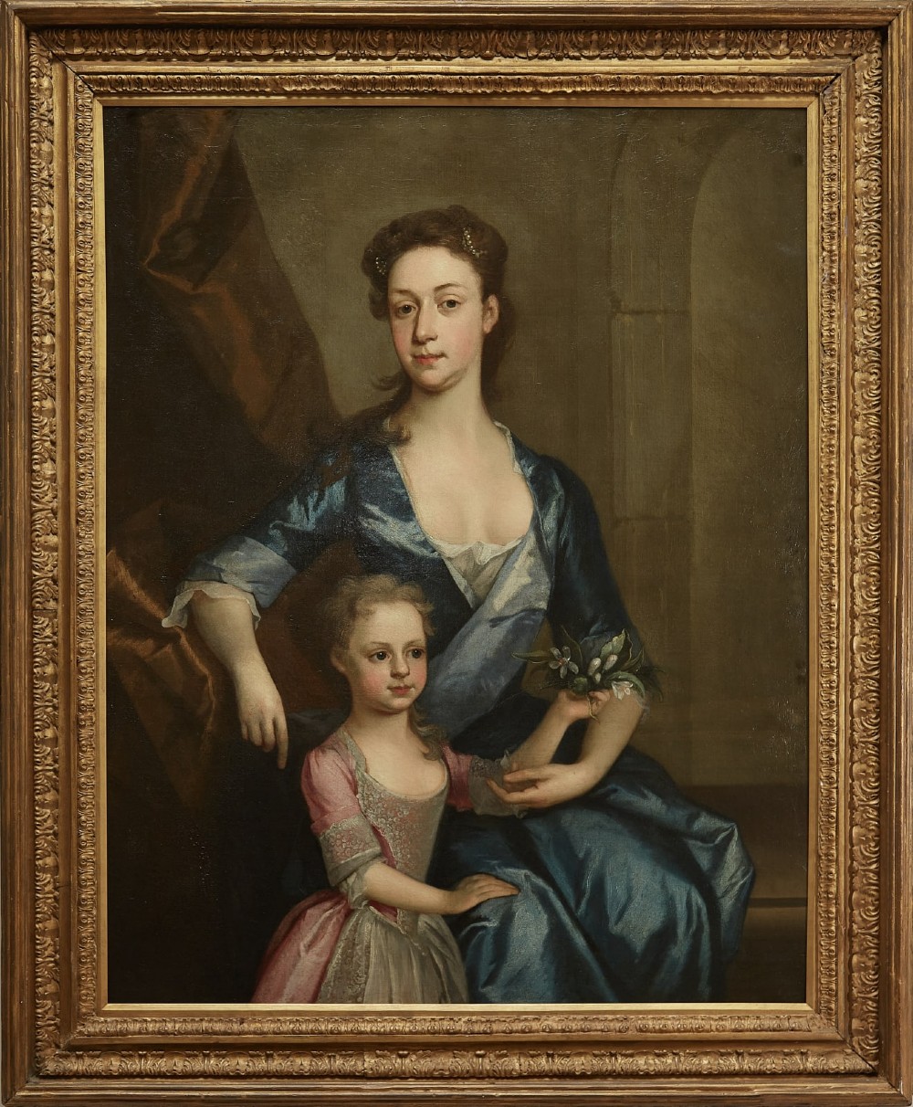 An eighteenth-century oil painting depicting a seated woman in a blue dress with a young child in a pink dress, presented within a carved gilt frame.