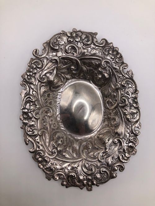 fig 1. An oval Victorian sterling silver dish with detailed repousse floral motifs and a scalloped scrolling edge.