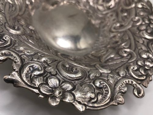 fig 2. An oval Victorian sterling silver dish with detailed repousse floral motifs and a scalloped scrolling edge.