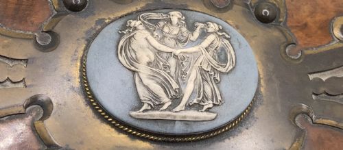 fig 1. A rectangular Victorian burr walnut box featuring decorative brass strapwork and a central oval blue cameo plaque depicting classical figures.