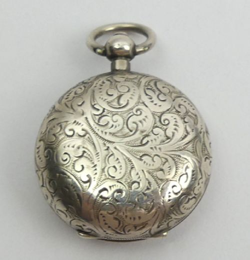 fig 1. A circular Victorian sterling silver sovereign case featuring intricate foliate hand-engraving surrounding a blank central cartouche with a top suspension loop.