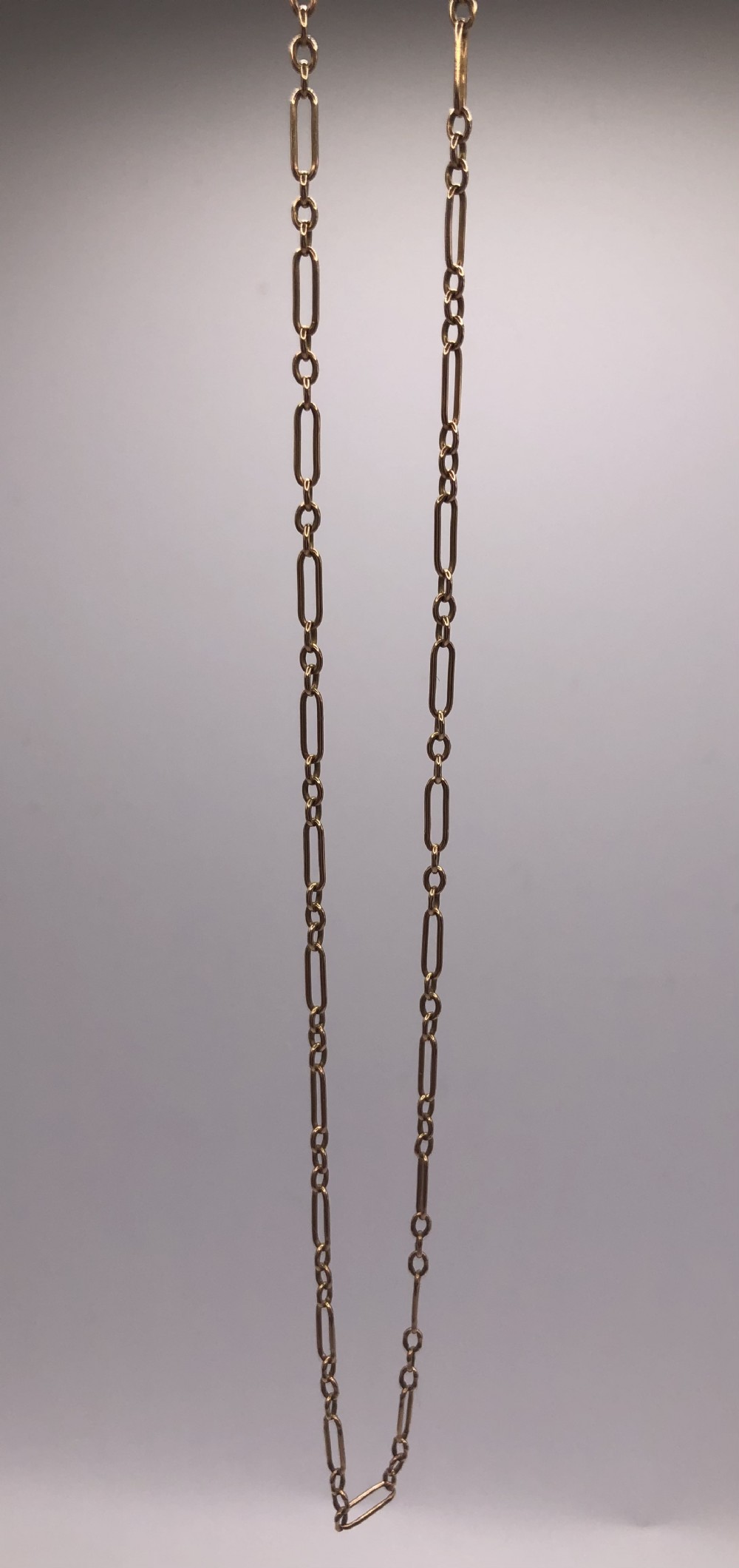 An antique Edwardian 15ct yellow gold chain featuring long paperclip links alternating with small circular connecting links.