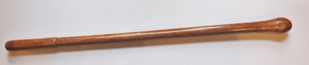 A long 19th-century hand-carved Oceanic wooden fighting club with a smooth grip, tapered shaft, and rounded bulbous head.