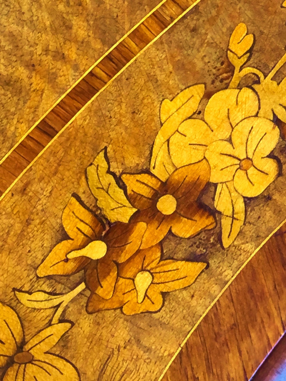 A 19th-century French Louis XV style inlaid writing desk featuring floral marquetry, a serpentine top, cabriole legs, and gilt-bronze mounts. View X
